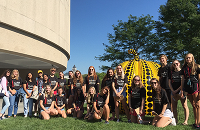 group of students pose outside museum