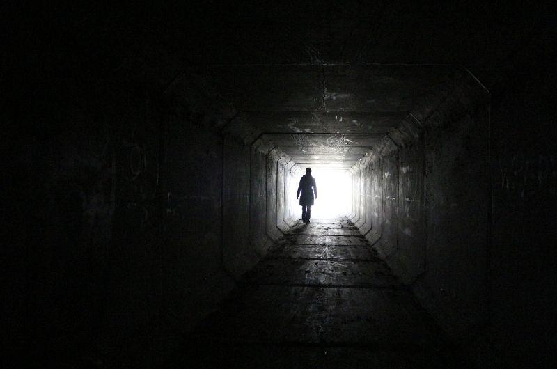 person in dark tunnel