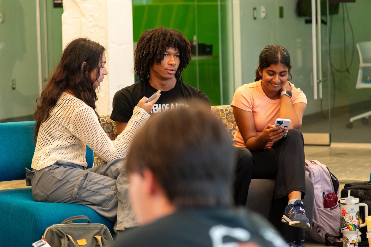 three students talking to other students